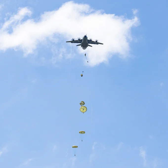 Paratroopers being dropped from the A400M, above them.