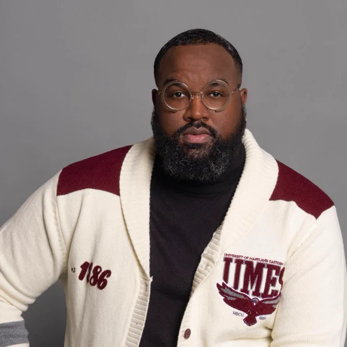 Photo of Stephon Fitzpatrick sitting on a stool in a white and red cardigan