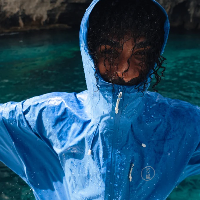 Person wearing a wet shoreline jacket with the hood up