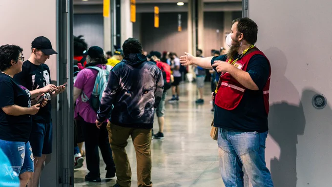 An Anthrocon Safety staff member helping to direct attendees into the Registration area.