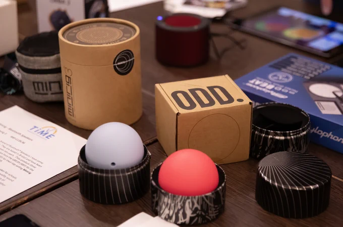 Photo shows some boxes, one of which says 'ODD.' There are two spherical musical instruments in containers.