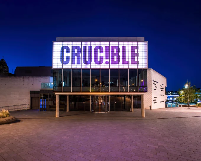 The Crucible theatre lit up in white at night-time. Photo by Smart Banda.