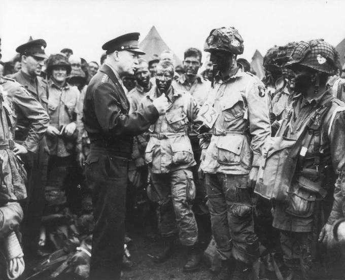 Supreme Allied Commander Gen. Dwight D. Eisenhower speaks and gives the order of the Day, with 101st Airborne Division paratroopers before they board airplanes and gliders to take part in a parachute assault. This was the first assault into Normandy as part of the Allied Invasion of Europe. June 6, 1944. U.S. Army photo.
