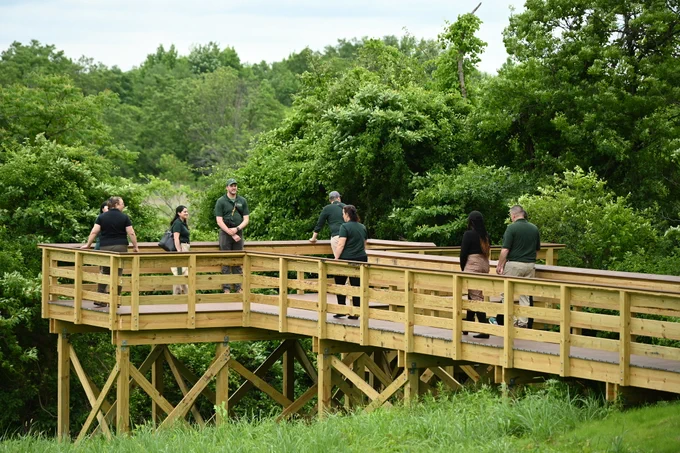Staff walk on a new accessible viewing platform at Mt. Loretto Unique Area.