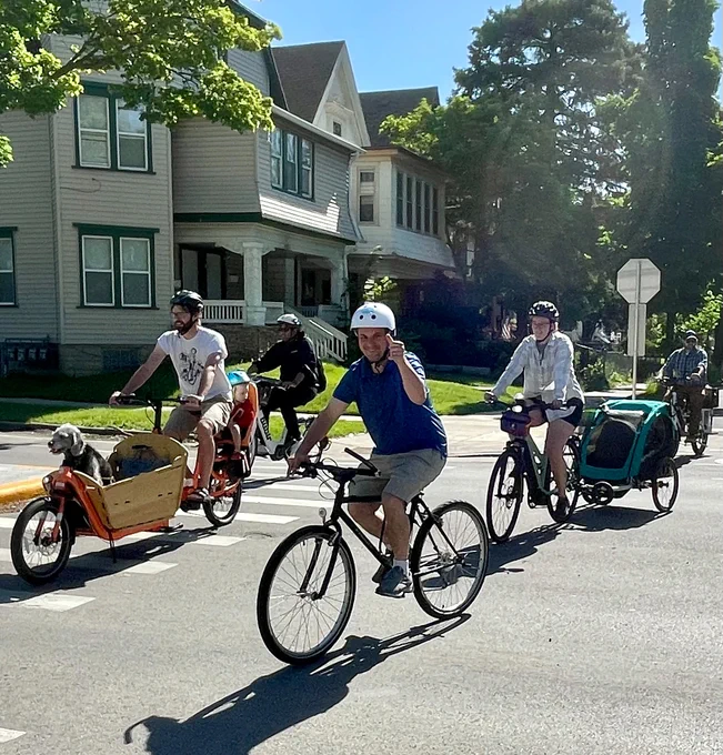 People riding bikes with houses in background