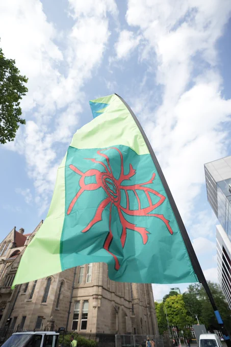 A green flag with a red bee logo