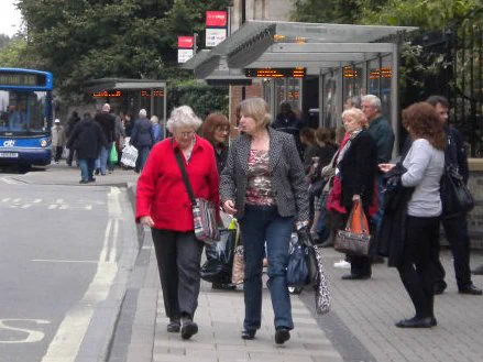 People walking and standing near bus stops