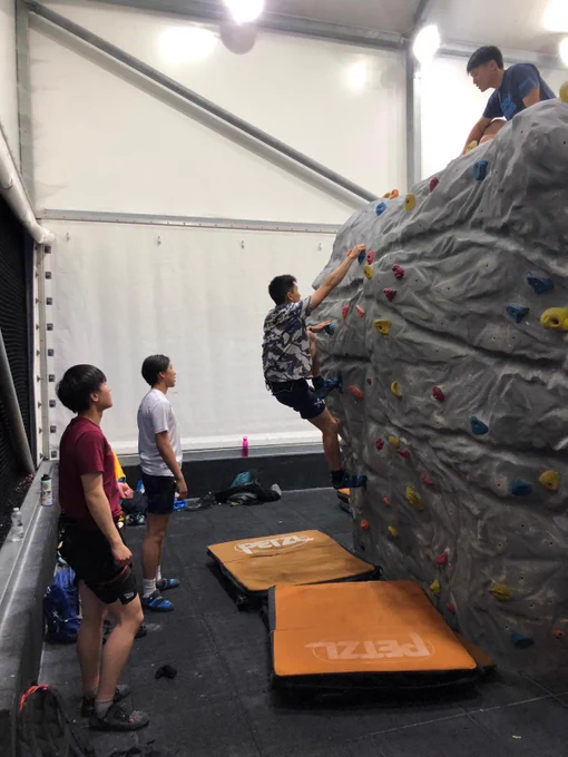 A boy climbing on a boulder wall