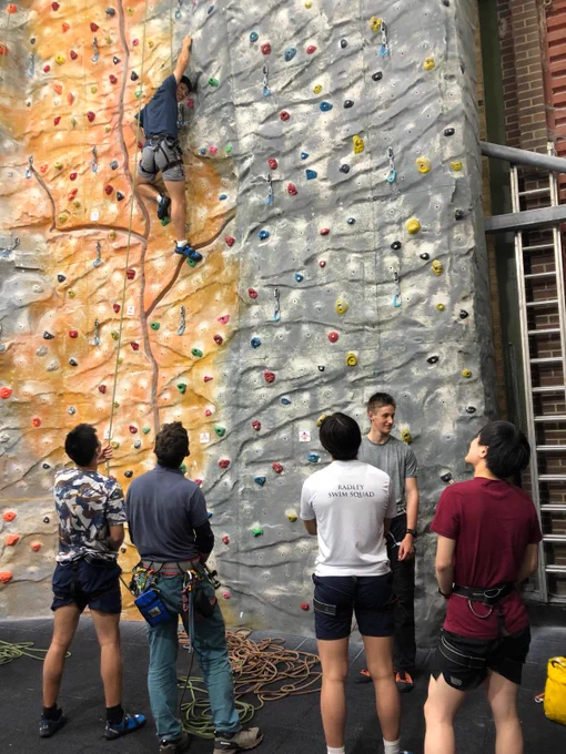 A boy climbing up an indoor climbing wall