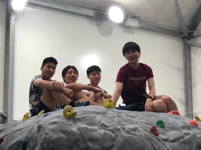 Boys sitting atop an artificial boulder problem 