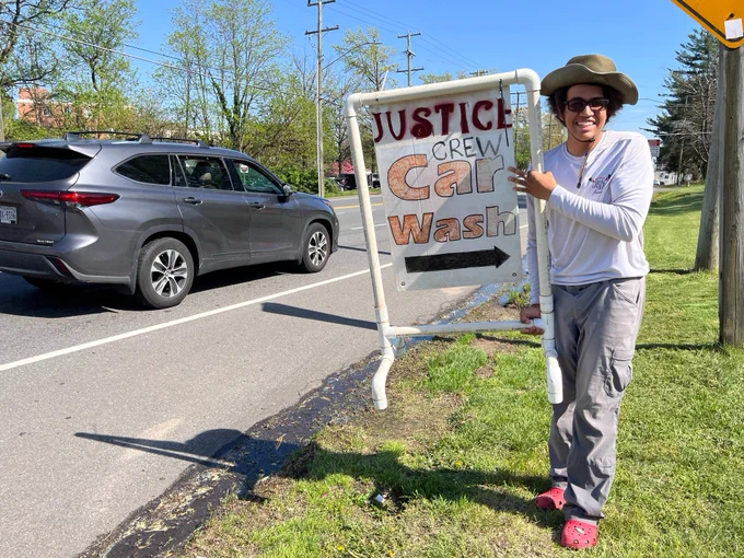 Justice Rower holding sign for June 9 car wash