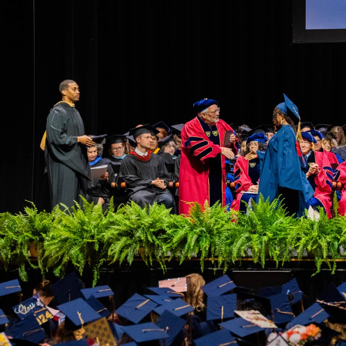 graduate crosses the stage during ceremony