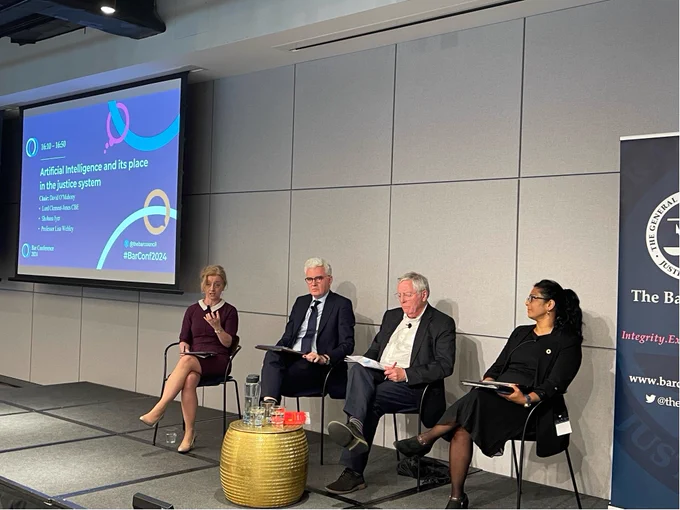 A panel of speakers sitting on a stage with Bar Conference 2024 branding. The speakers are: Lisa Webley, David O'Mahony, Lord Clement-Jones and Shobana Iyer. Lisa Webley is speaking