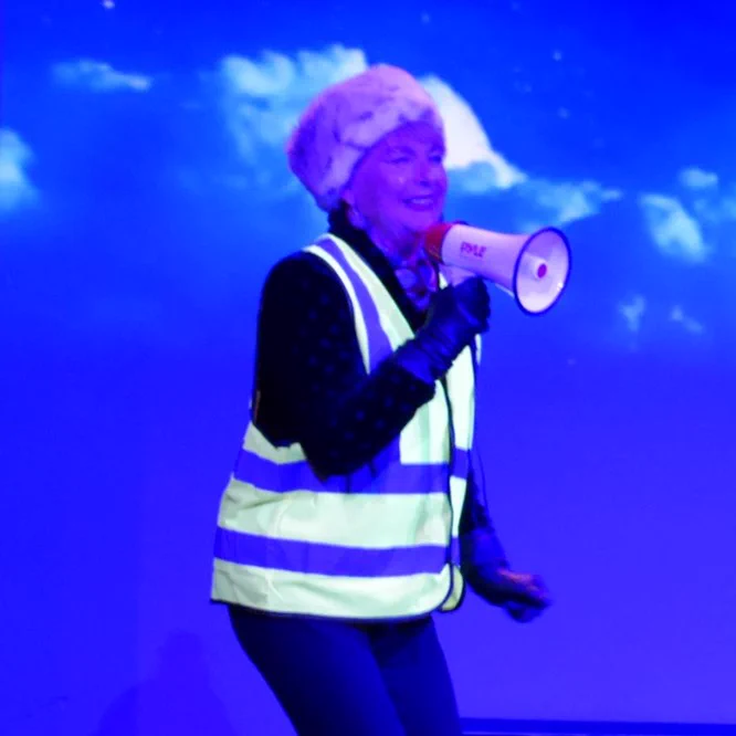 A character in Cheshire Cats.  She is a route marshal, speaking through a megaphone.