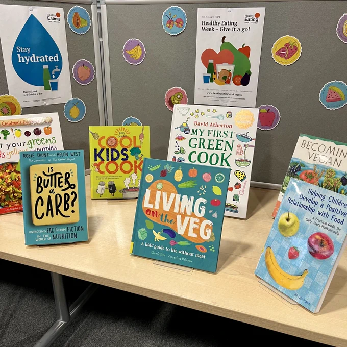 A display of books on healthy eating with colourful images of fruit in the background.