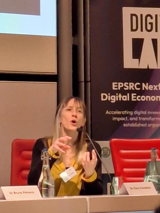 A picture of Clara Crivellaro speaking on a panel. 