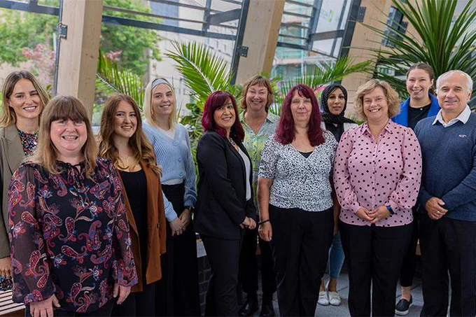 The Outreach and Recruitment Team standing together smiling in the Bright Building. 