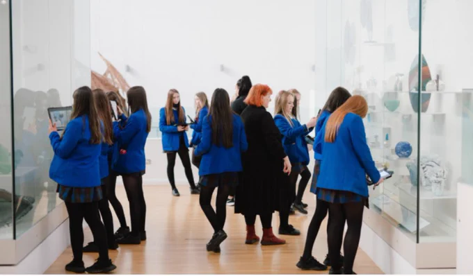 Female school pupils in blue blazers in an art gallery at a museum