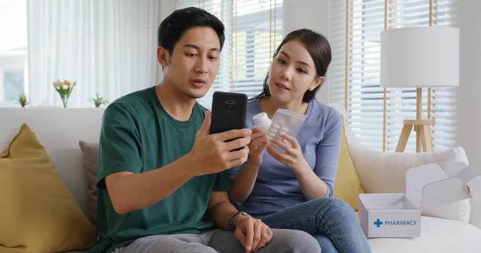 A young couple look at their phone for trusted medical information.