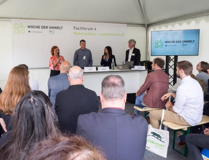 Blick auf das Fachforum des IÖR zum Thema "Erneuerbare Energien und Flächenschutz: Wie kann das gelingen?". Im Hintergrund das Podium, im Vordergrund die Besucher des Forums.