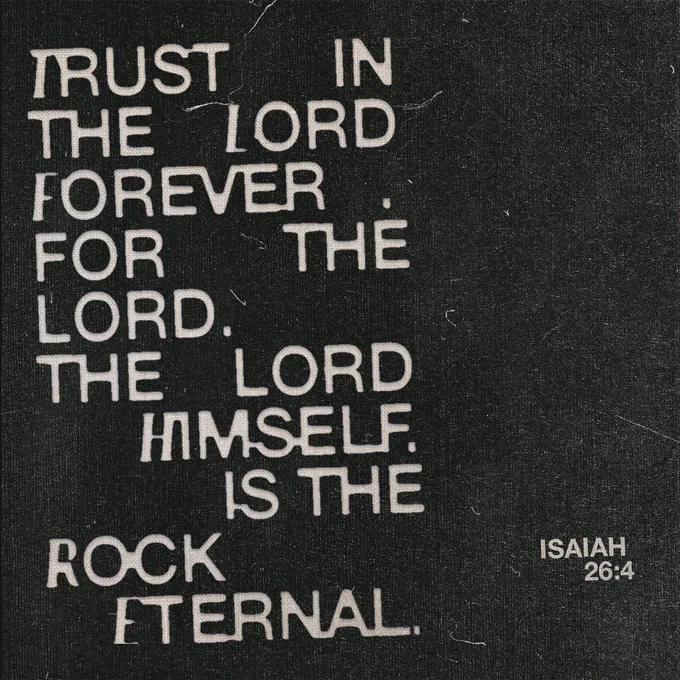 The image shows a textured, black background with white text in various font sizes. The text reads, "TRUST IN THE LORD FOREVER FOR THE LORD, THE LORD HIMSELF, IS THE ROCK ETERNAL. ISAIAH 26:4." The words "TRUST," "LORD," and "ROCK ETERNAL" are emphasized in larger, bold fonts.