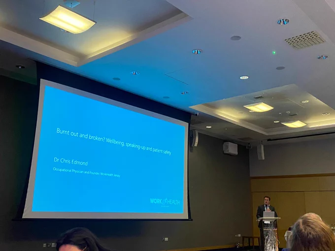 A photo of Dr Chris Edmond presenting at a conference on the links between burnout, speaking up, moral injury and patient safety.
