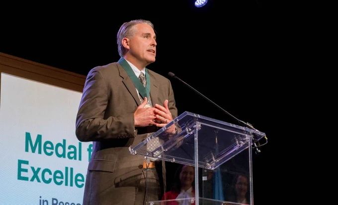 Dr. Greg Burge, OU economics professor and department chair, gives his acceptance speech for the Medal for Excellence in Research University Teaching on stage at OFE's Academic Awards Celebration.