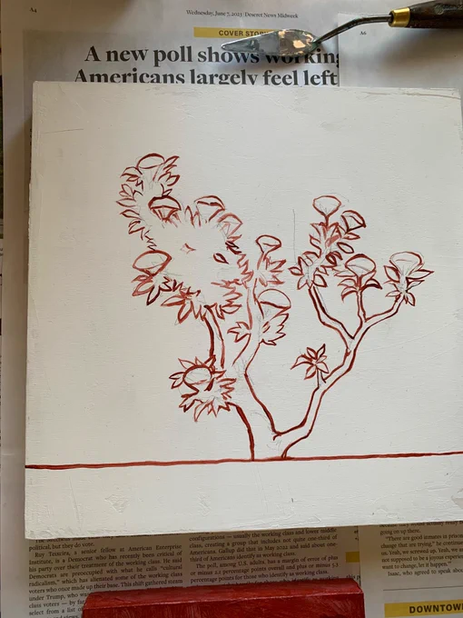 A square gessoed board with a drawing on red of a small flowering shrub.