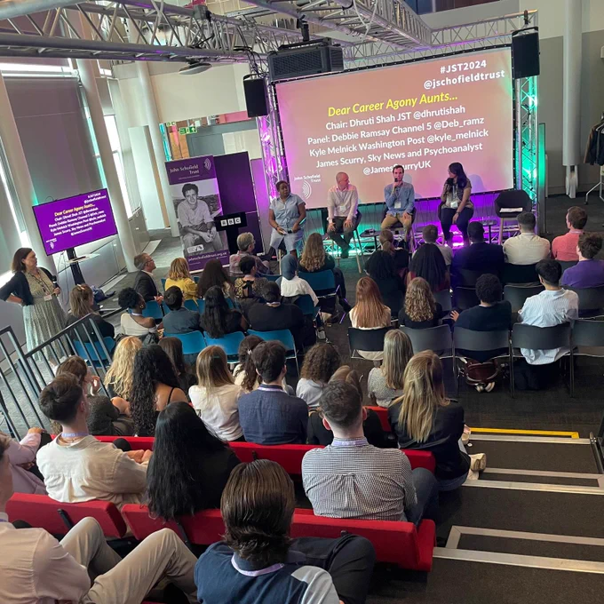 A room at the BBC with an audience looking at a panel and screen with the text 'Dear Career Agony Aunts' and a list of speakers.