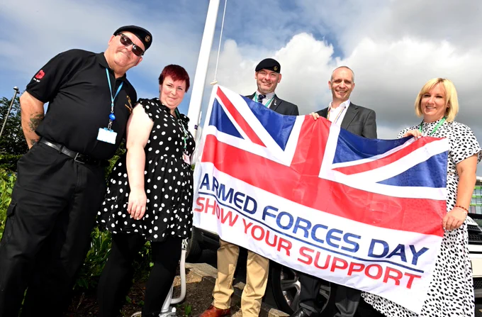 Members of Sherwood Forest Hospitals' Armed Forces Network are pictured holding the Armed Forces Day flag outside King's Mill Hospital
