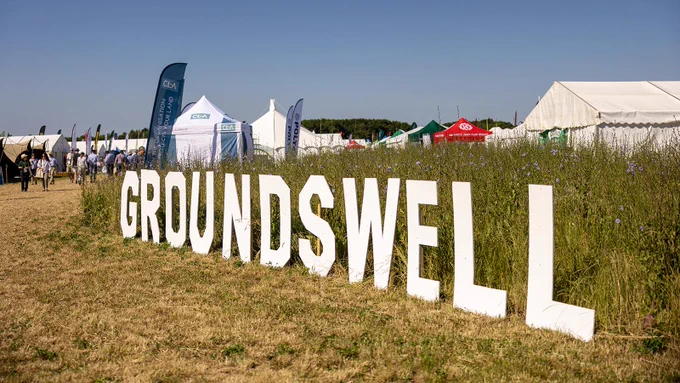 Sign at the Groundswell event saying Groundswell with tents and flags in the background