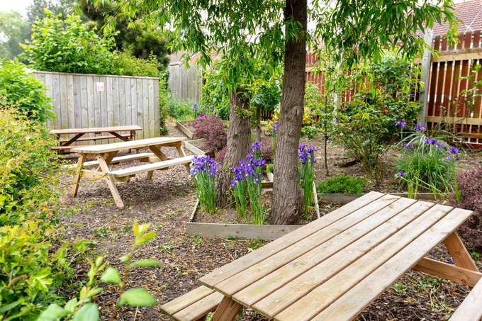 Picnic benches amongst a neat nature garden outside The Deep Business Centre.