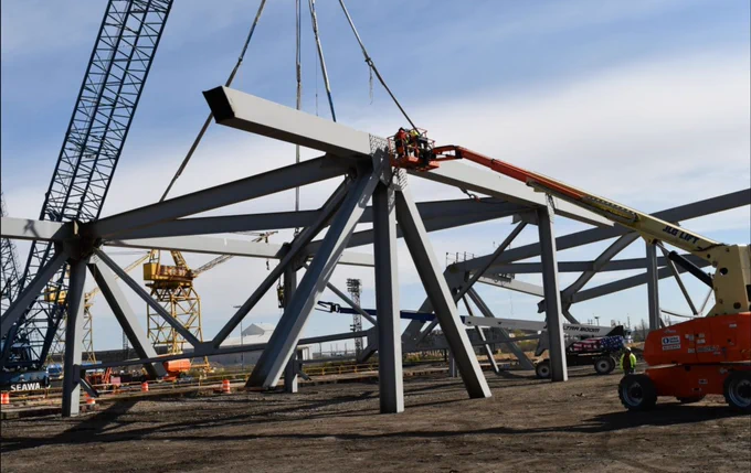 Grey steel debris and fixtures lifted up by a crane