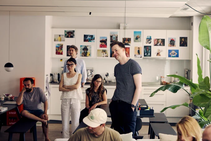 Our team sitting and standing in the kitchen of our studio.