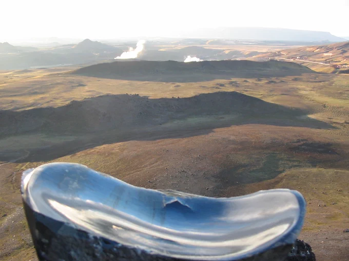 If you don't mind me stating so, this is quite a cool photo of obsidian at Krafla, Iceland. In the background you can see distant parallel ridges created by fissure eruptions.
