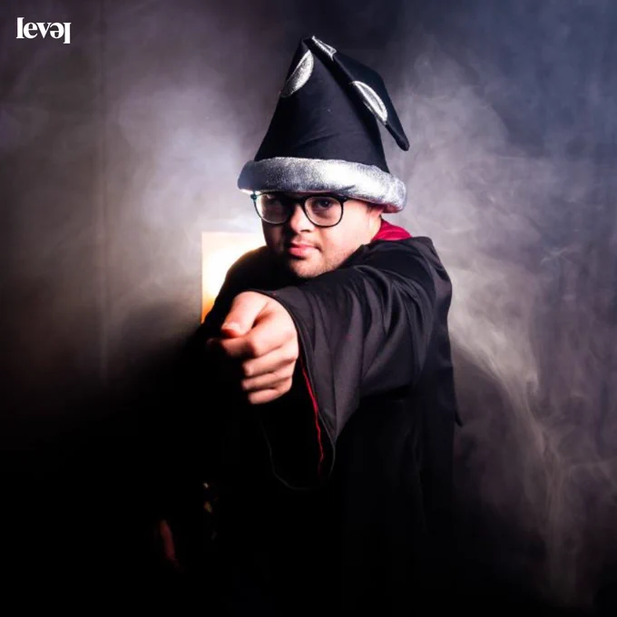 A person dressed as a wizard with black and white smoke in the background.