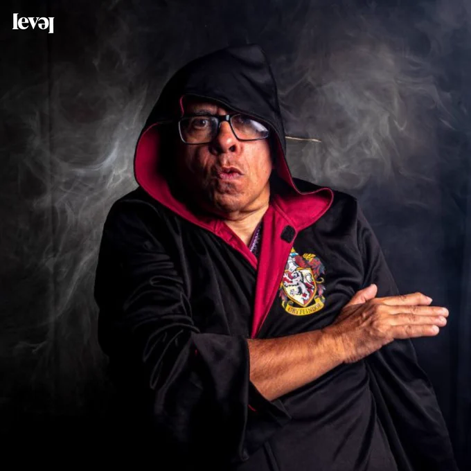 A person dressed in a wizards cloak with black and white smoke in the background.