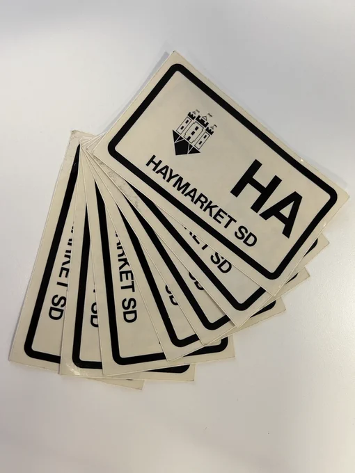 A selection of stickers with a crest, the letters HA and words, Haymarket SD.