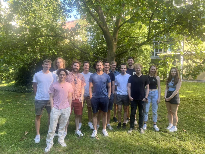 Members of the IPA lab led by Jürgen Cito standing in the garden of the faculty of Informatics at TU Wien