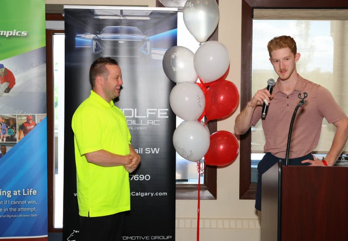 Dustin Wolf on the mic, with Special Olympics athlete David Nicholson looking on