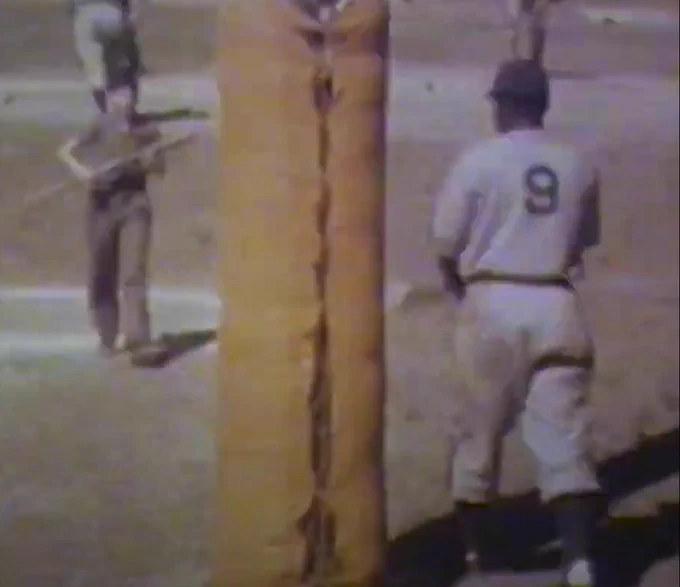 Screengrab of Jackie Robinson walking to the plate, wearing the No. 9