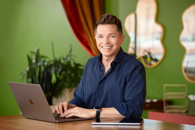 Photo of Tony Vincent smiling while sitting in front of a computer