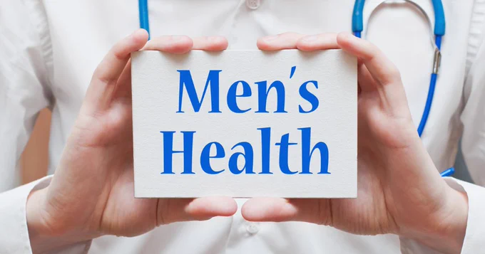 Image of a doctor wearing a stethoscope holding a card saying men's health