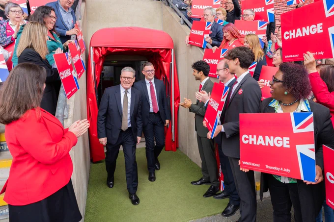 A photograph of Keir walking out of a tunnel to meet people at an event.
