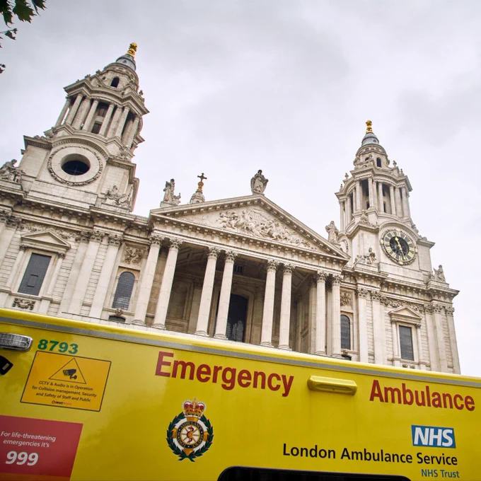 Image shows the top of an emergency ambulance with St Pauls Cathedral visible in the background. A message on the ambulance reads: 'For life-threatening emergencies, it's 999'