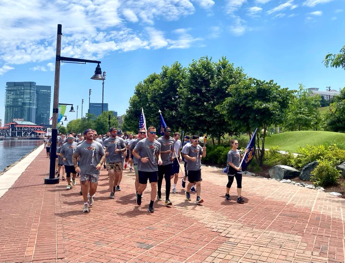 Law enforcement officers run with athletes from the Special Olympics. 