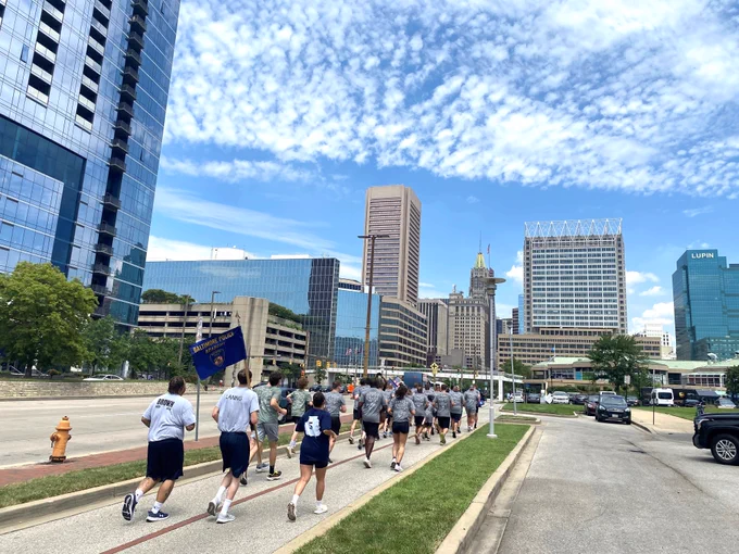 Law enforcement personnel run through the Baltimore inner harbor. 