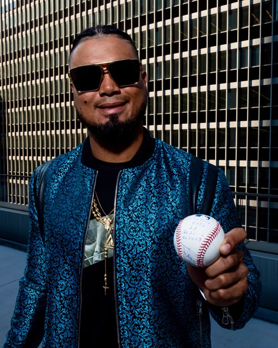 Luis Arraez holds out an autographed baseball that YOU could win.