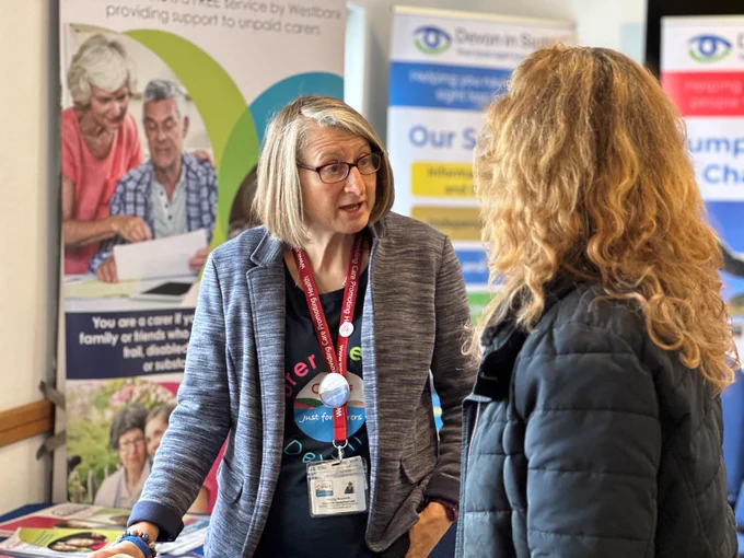 Hayley from Devon Carers talking to an attendee about their Services.