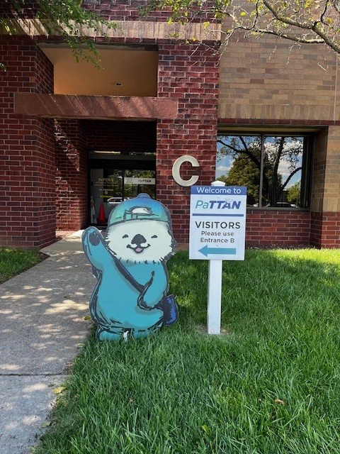 Photo of an illustrated cardboard cutout of a sea otter standing outside PaTTAN Central.